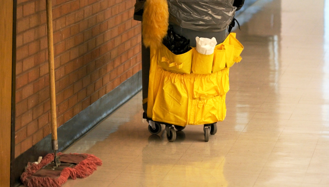 garbage can with cleaning supplies and a broom