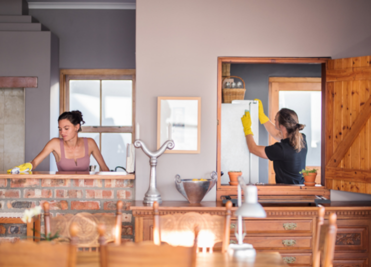 Two people deep cleaning house wearing yellow gloves