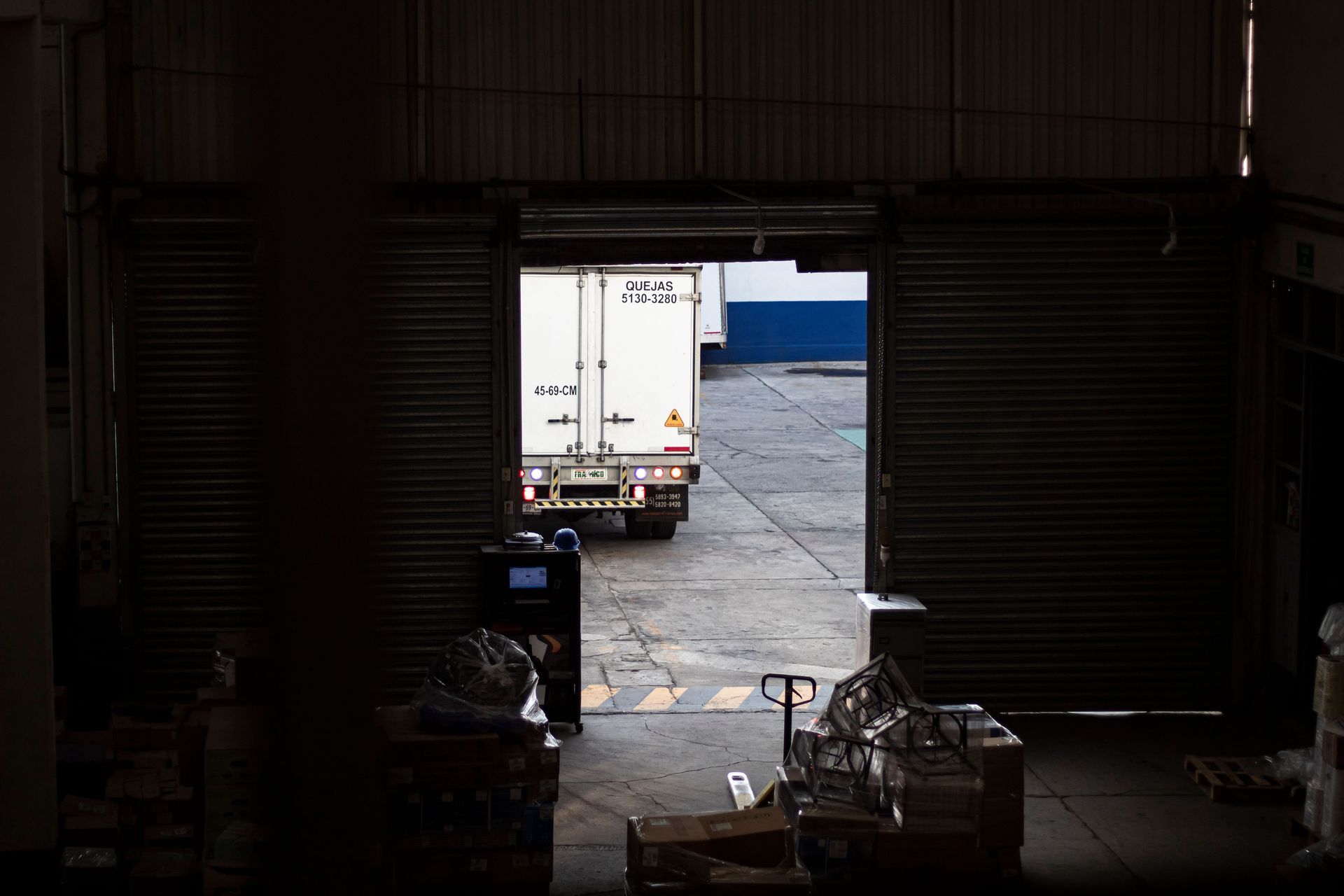 A white truck backing up to a loading bay.