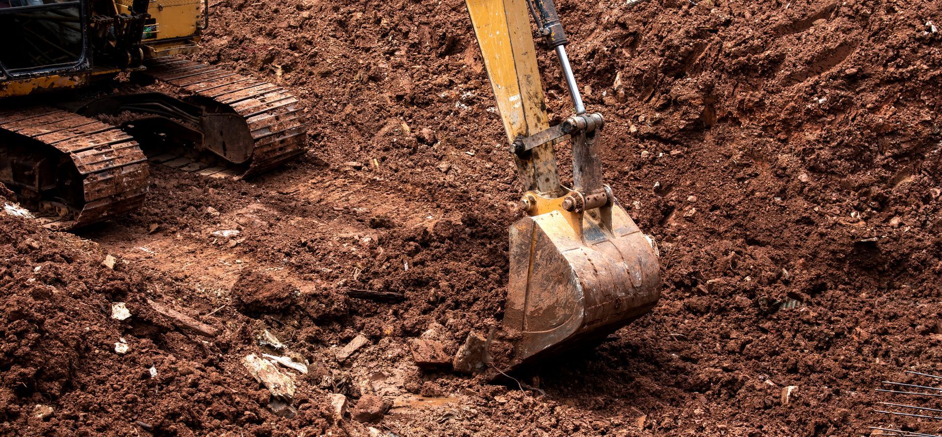 Excavator digging brown soil at a construction site