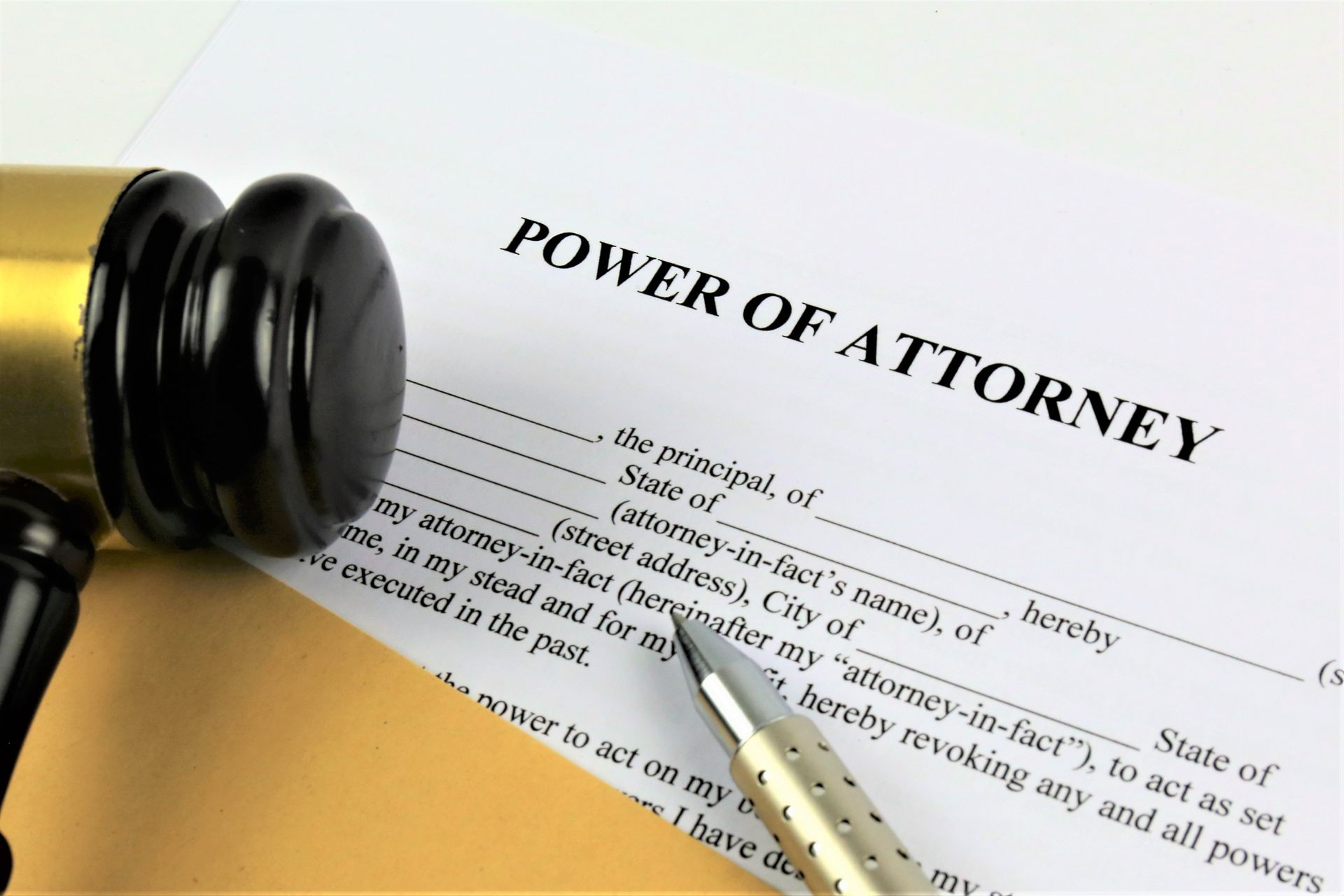 Power of attorney document with a judge’s gavel and pen on a white desk