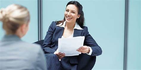 A woman is holding a piece of paper during a job interview.