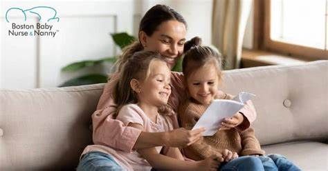 A woman is sitting on a couch reading a book to two little girls.