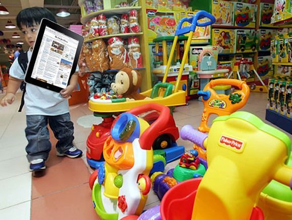 A little boy is holding a tablet in a toy store