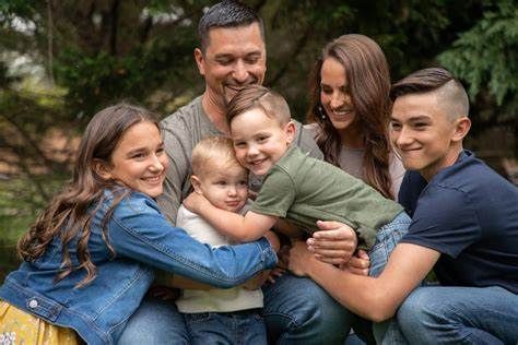 A family is posing for a picture together in a park.