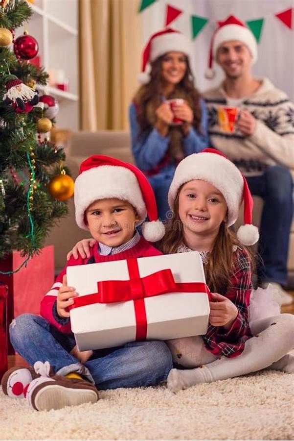 A family is sitting in front of a christmas tree holding gifts.