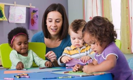A woman is sitting at a table with three children.