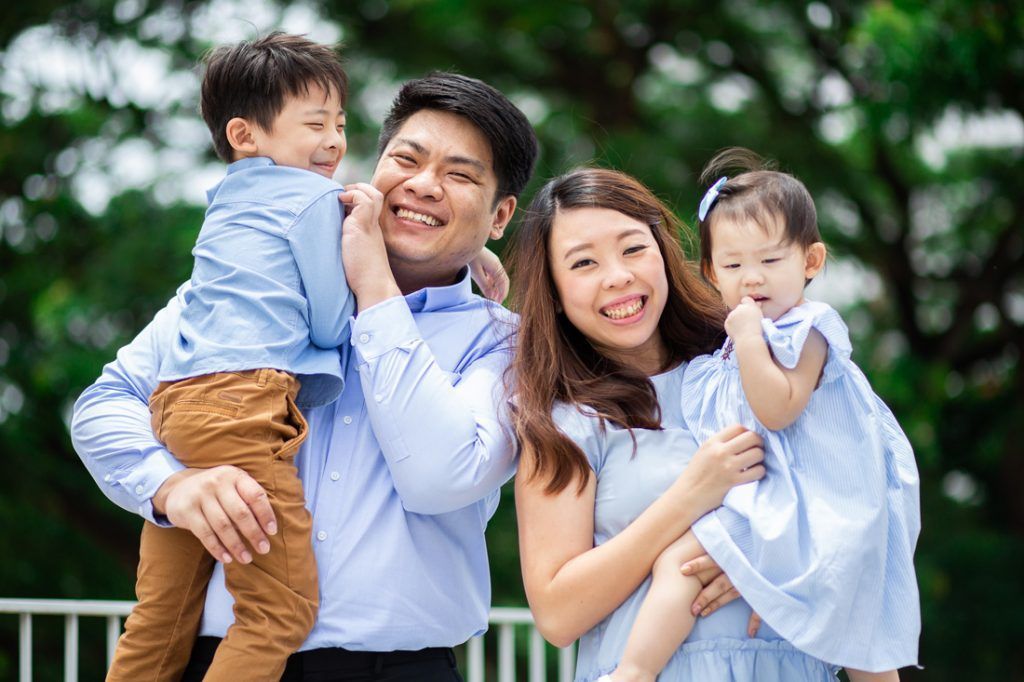 A family is posing for a picture together in a park.