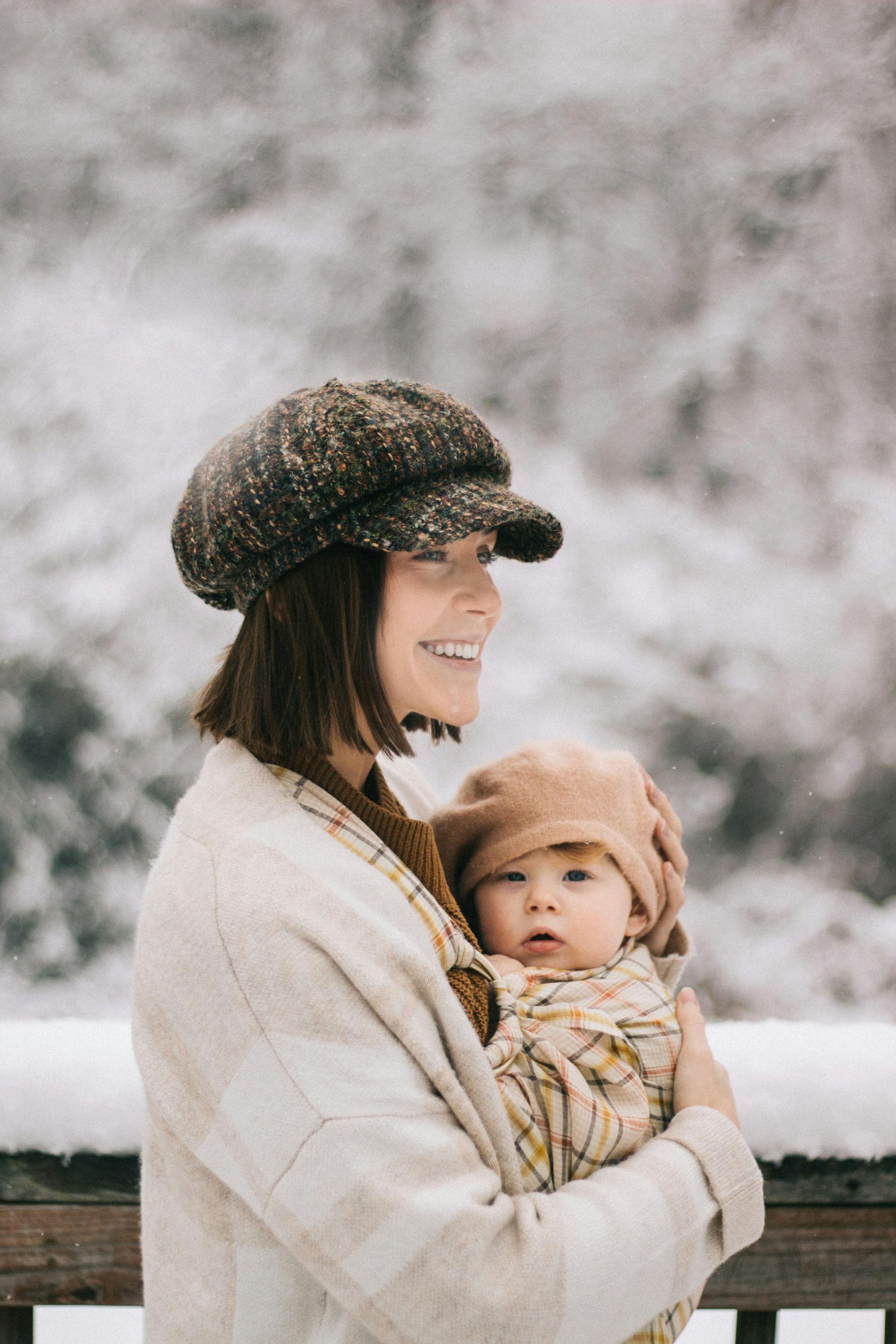 A woman is holding a baby in her arms in the snow.