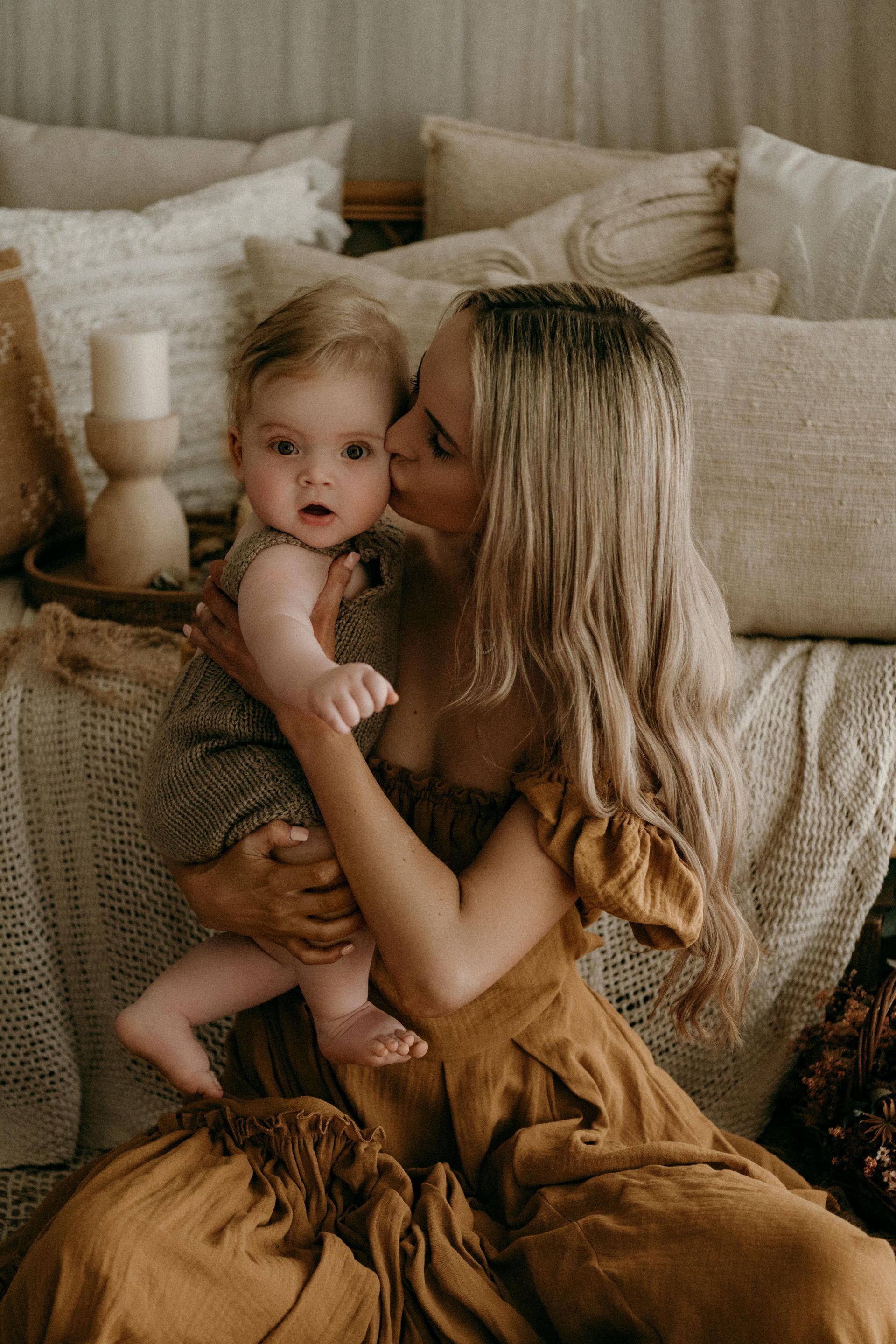 A woman is hugging two children in a room.