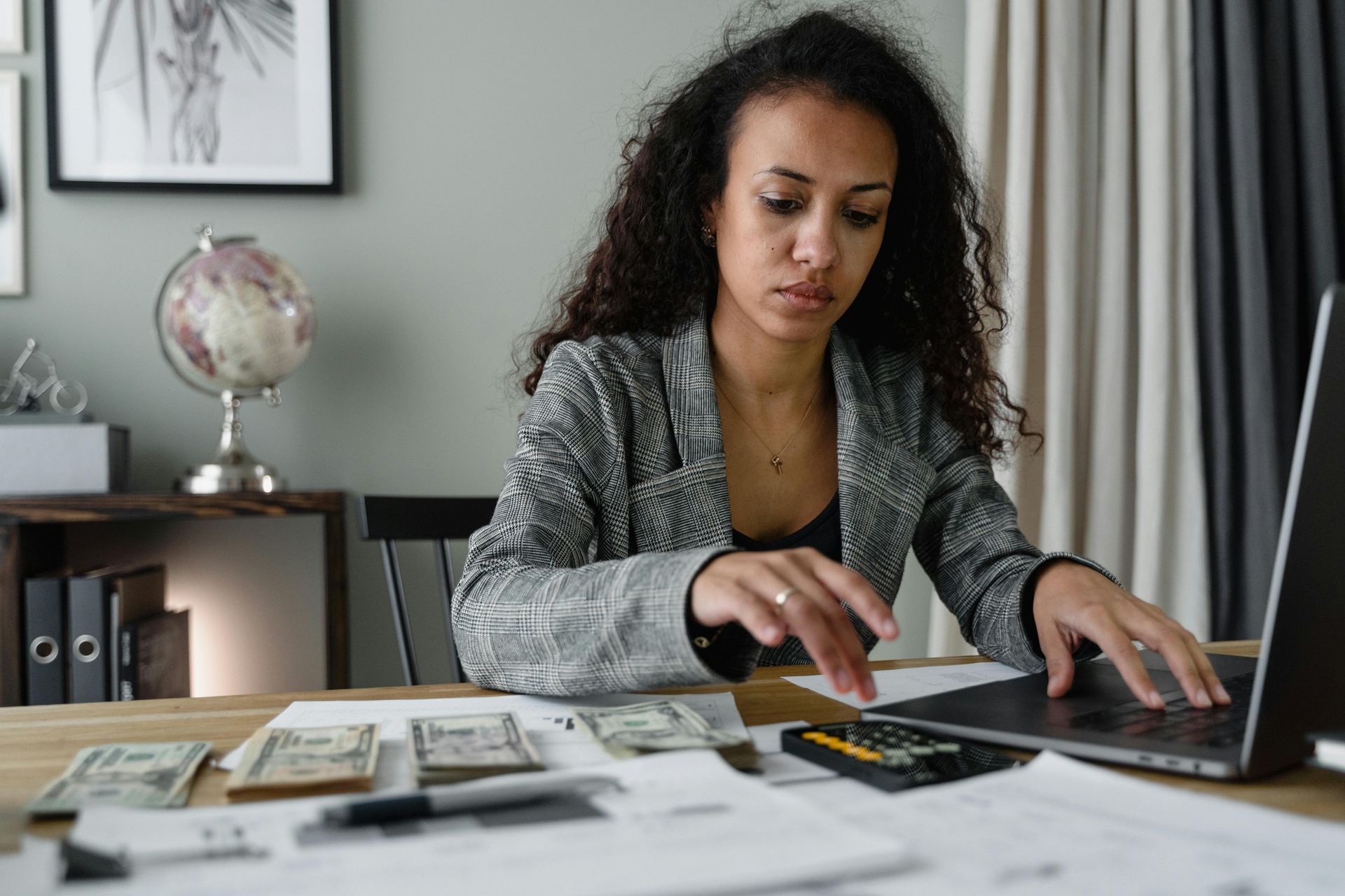 A woman is sitting at a desk using a laptop computer.