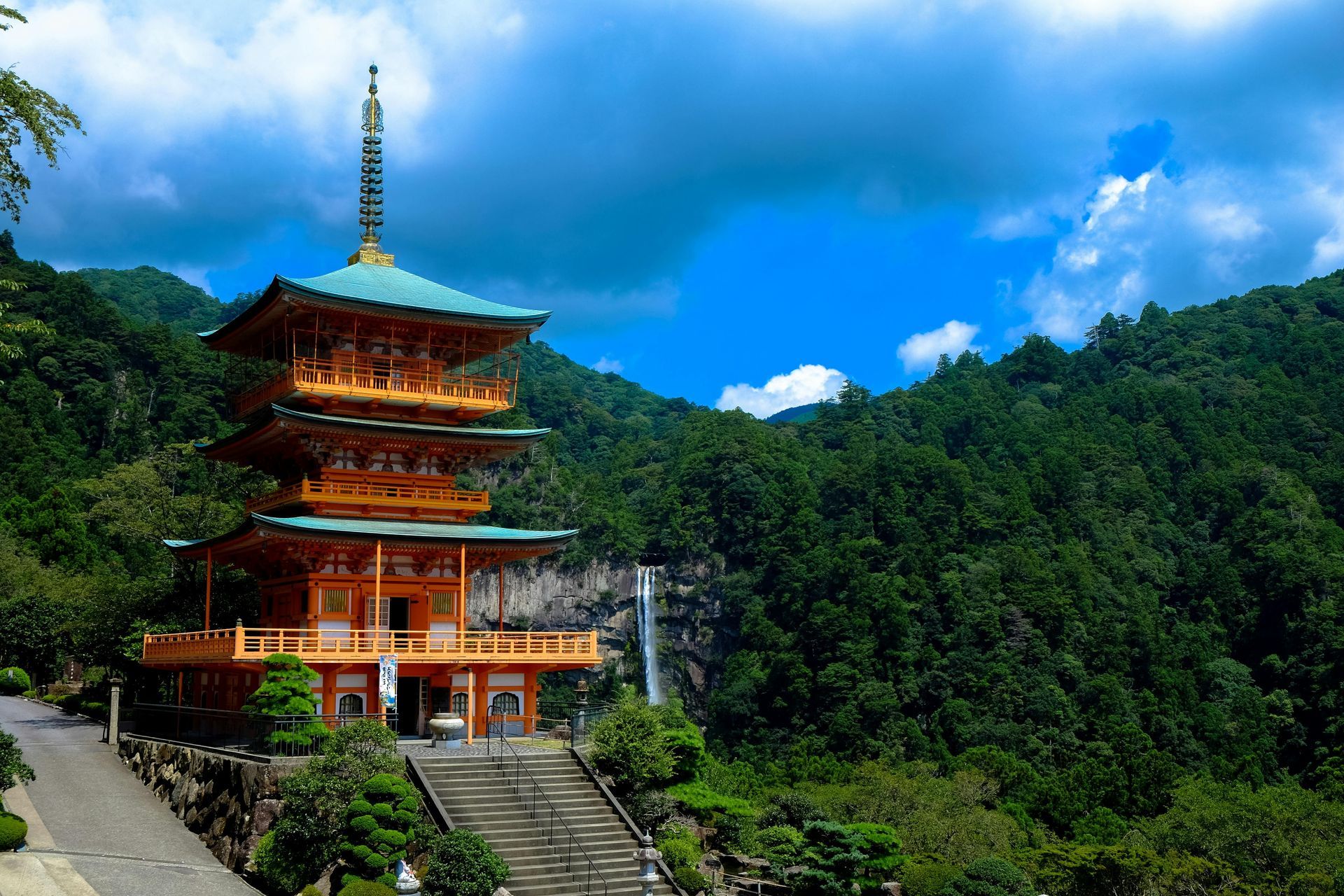 A pagoda in the middle of a forest with mountains in the background