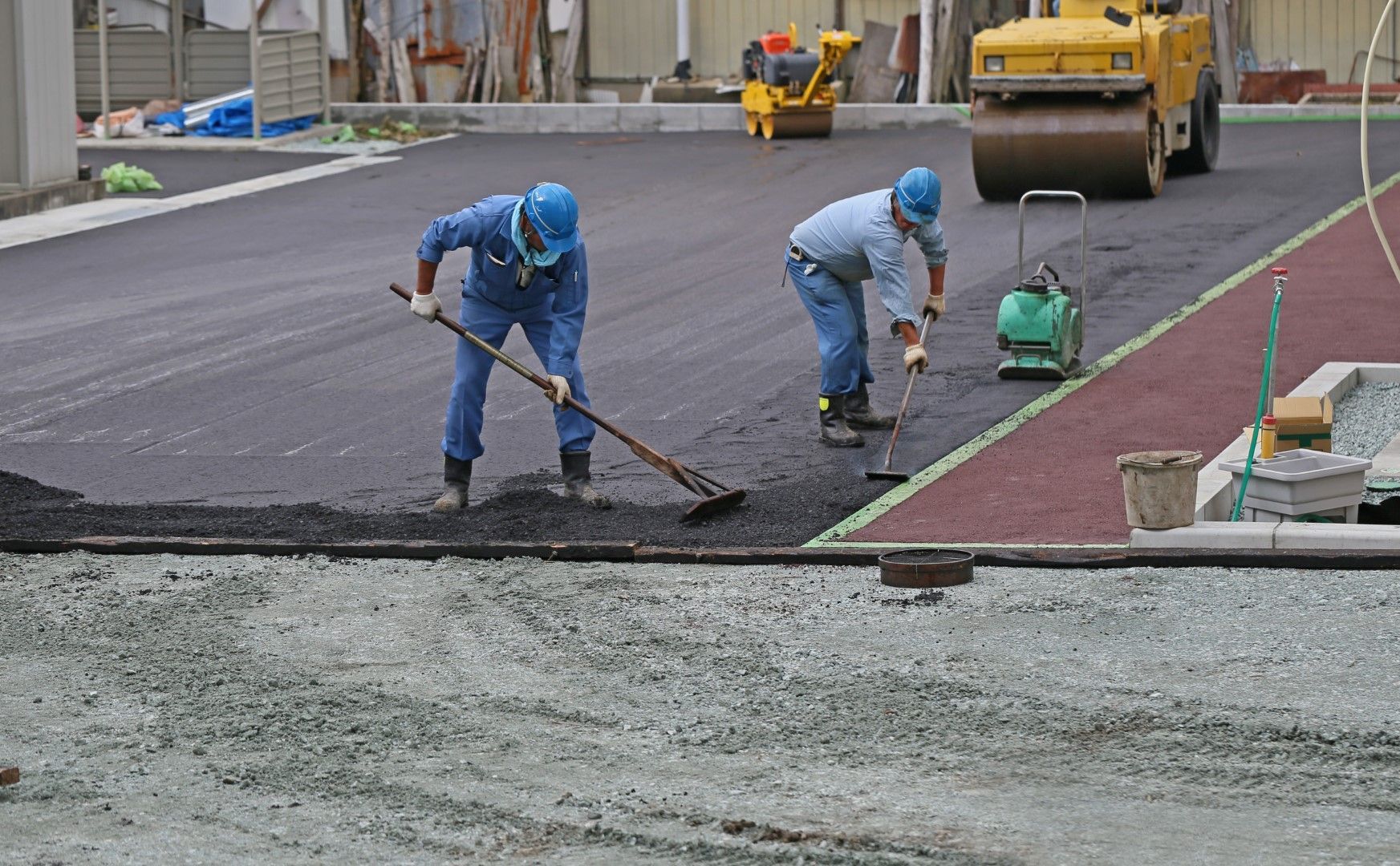 A group of construction workers are working on a road.