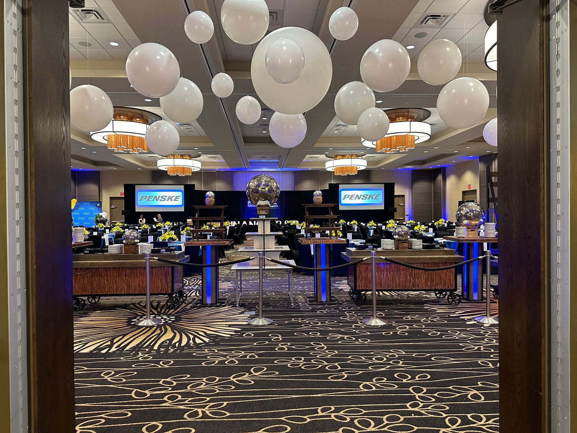 Casino gaming floor with blackjack tables, blue lighting, and large white balloon-like ceiling decorations