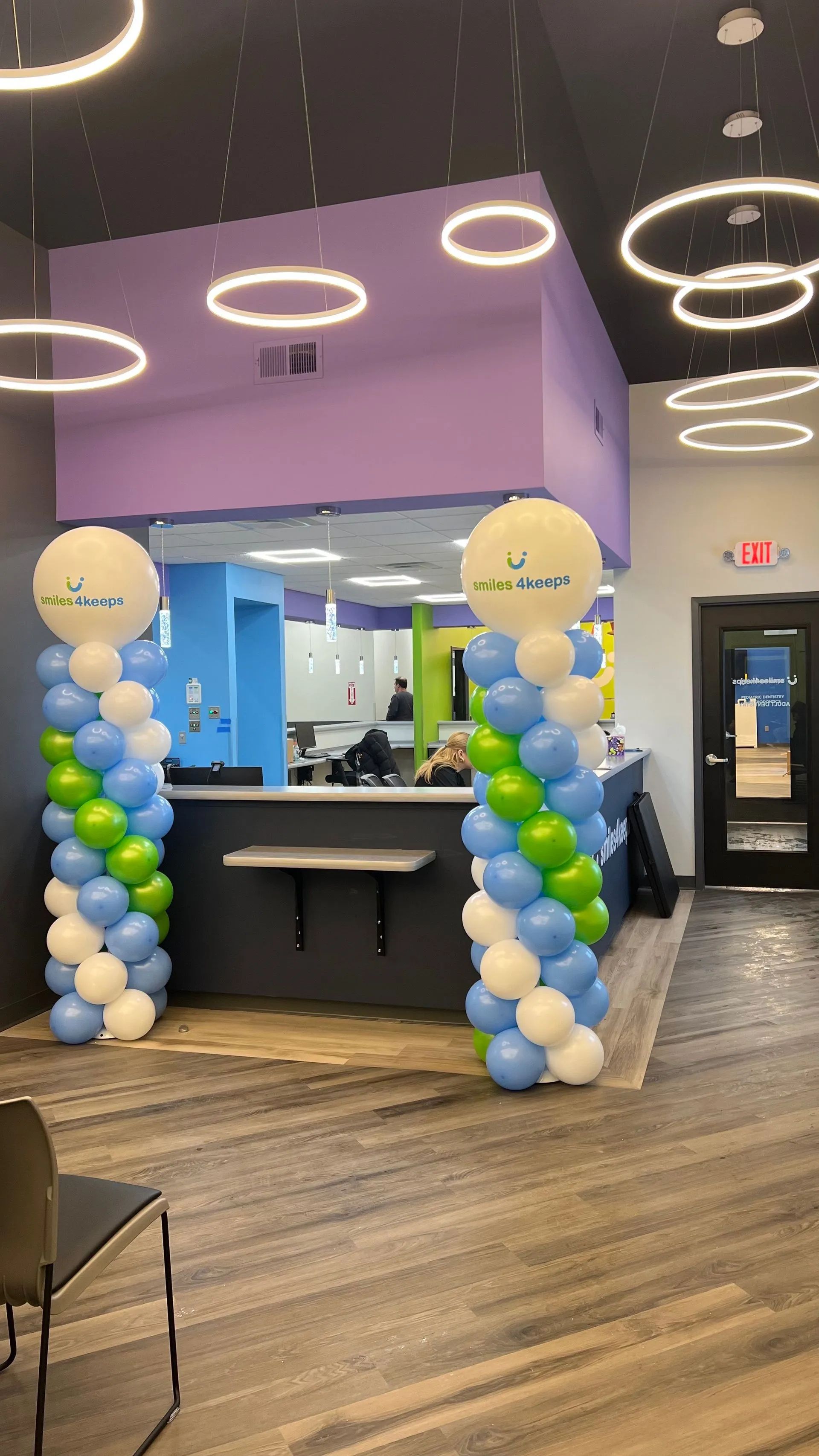 Entrance to business, reception area, decorated with balloon columns, modern design.