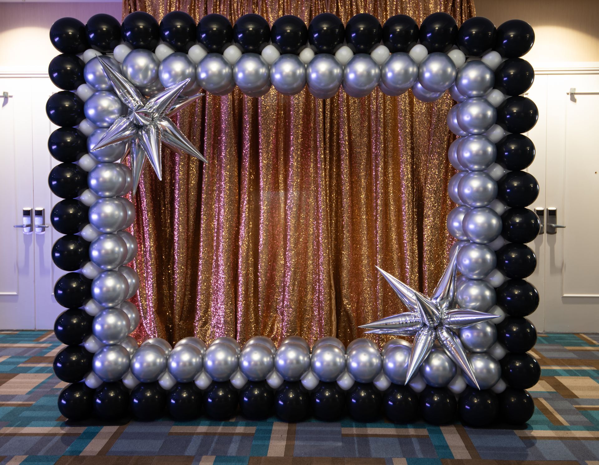 Balloon photo frame, black and silver balloons, with gold sequin backdrop and star accents.