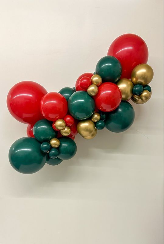Balloon garland in shades of blue and orange, affixed to a white wall.