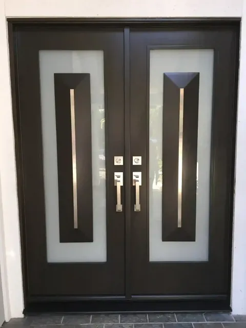 Black double doors with frosted glass panels and silver handles in a doorway