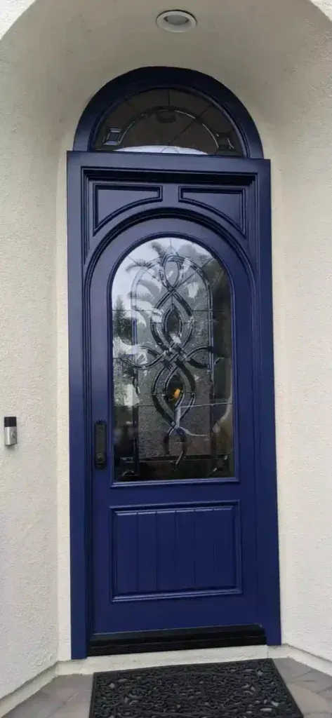 Blue front door with arched glass sidelights in a stucco entryway