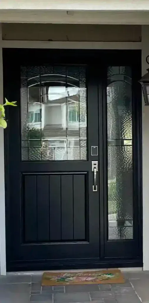 Black front door with frosted glass side panel at a house entrance