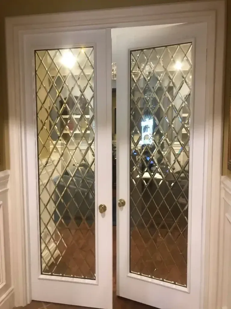 White French double doors with diamond-pattern glass panels in a hallway