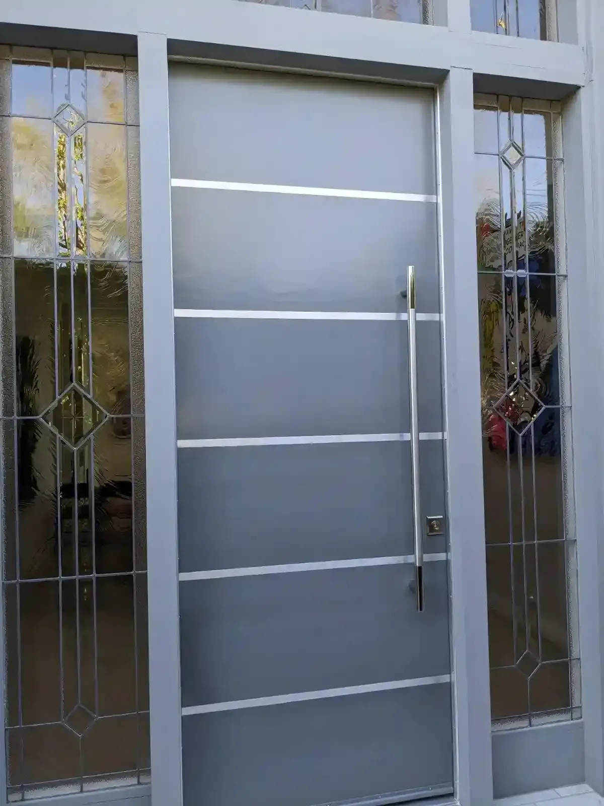 Modern gray front door with glass side panels and vertical handle