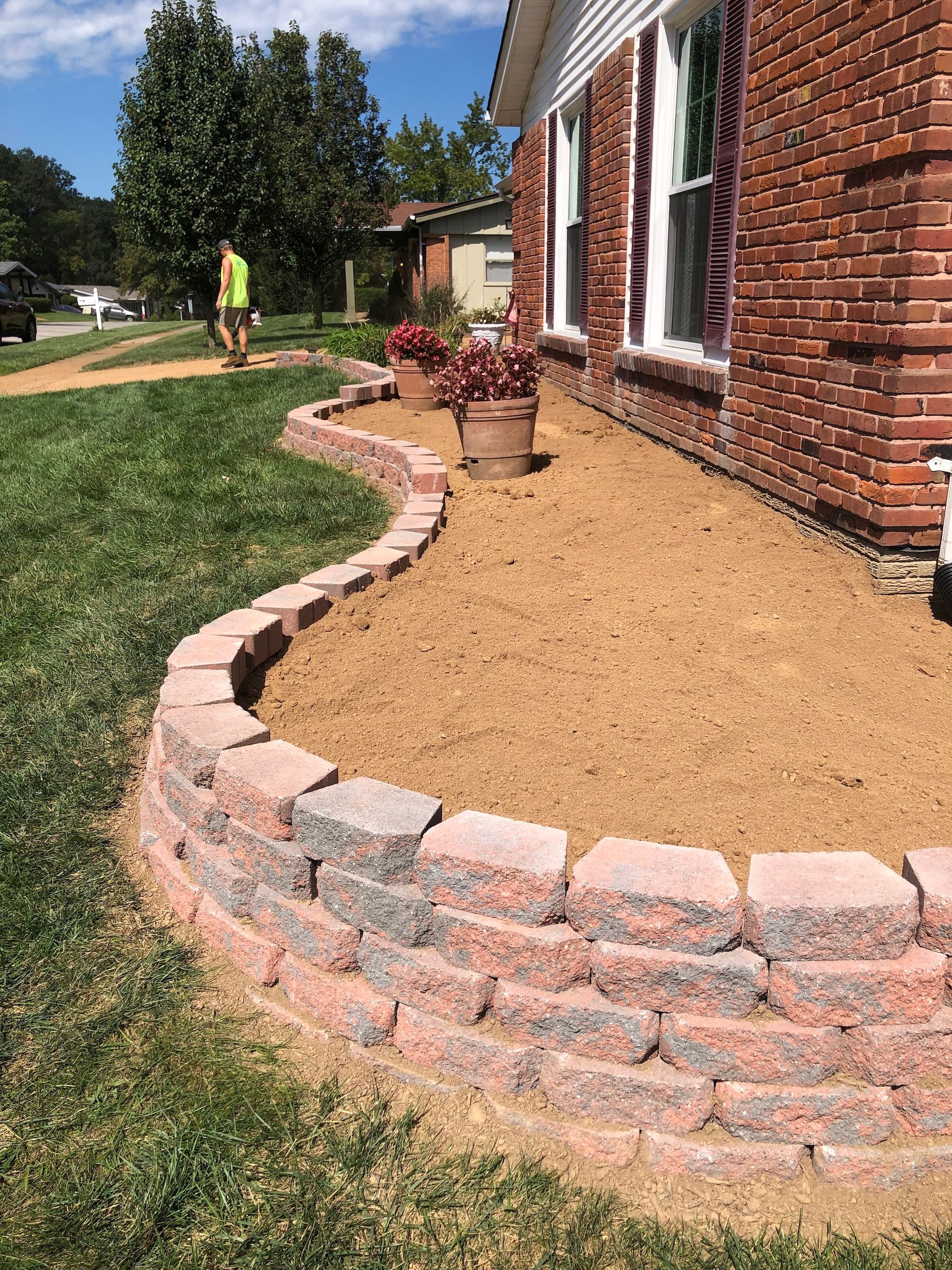 Retaining wall with dirt and new plants installed.