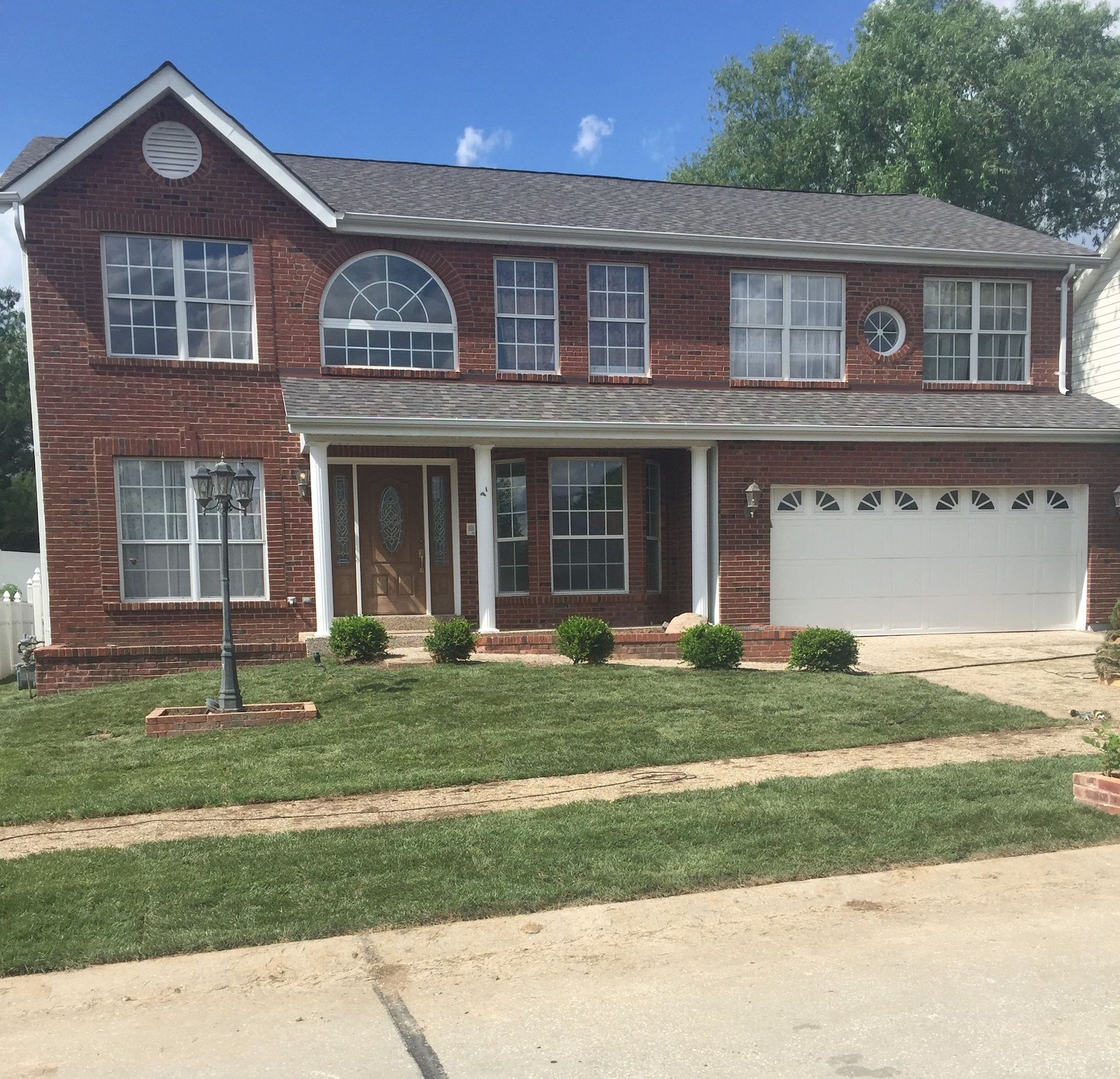 A large brick house with a lawn installed with fresh sod.