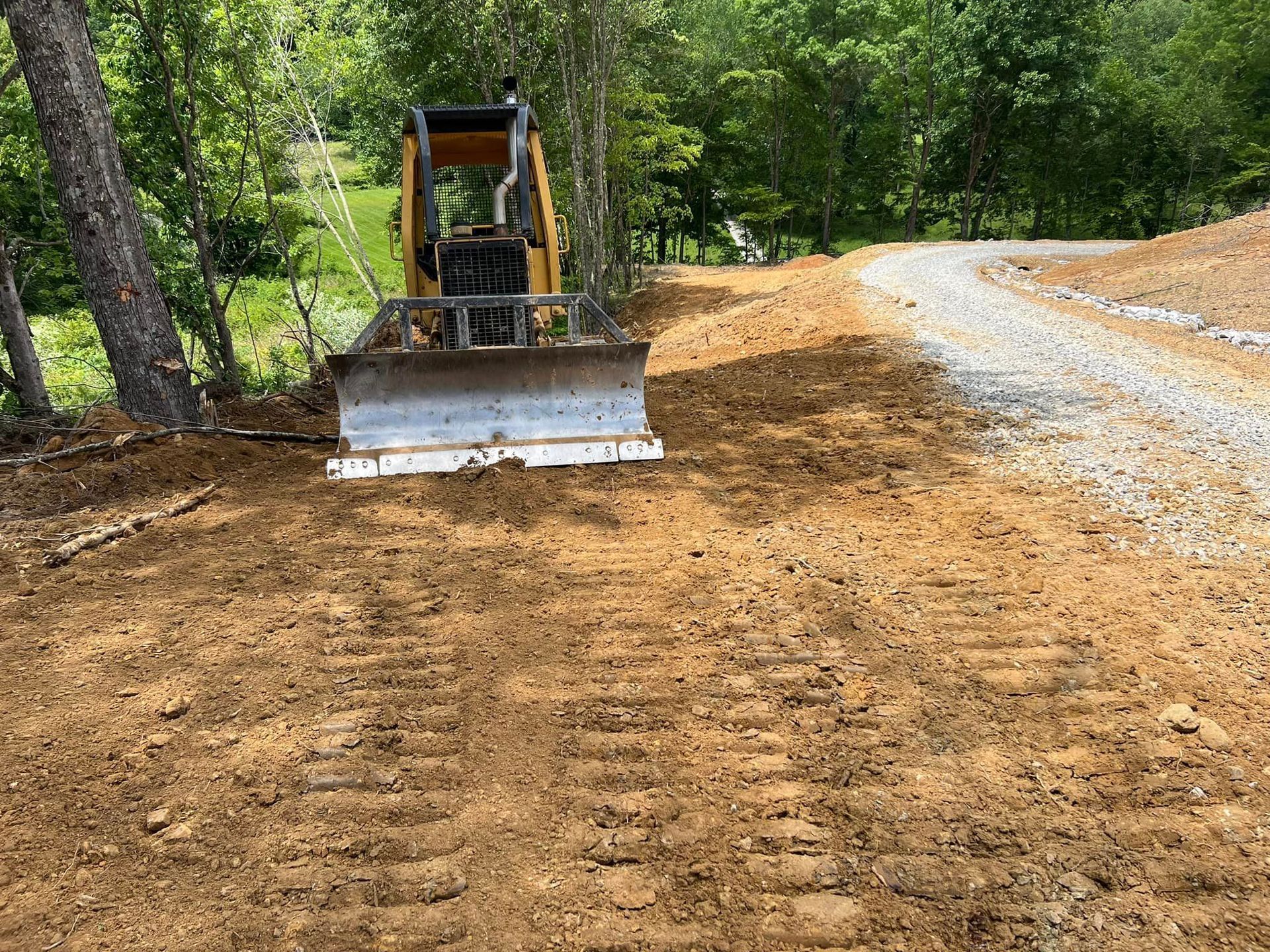 A bulldozer is driving down a dirt road.
