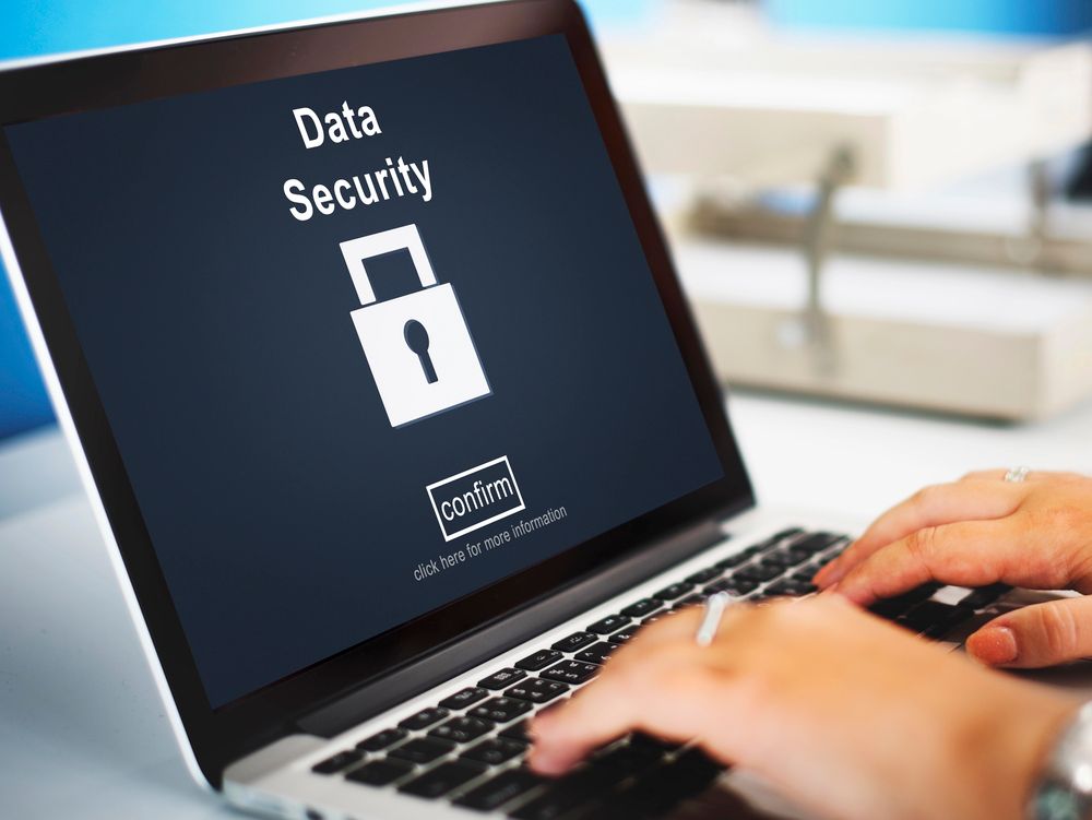 Laptop screen showing “Data Security” with a lock icon while someone types on the keyboard