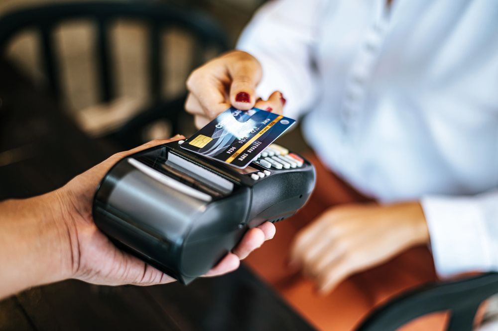 Handing a credit card to a contactless payment terminal