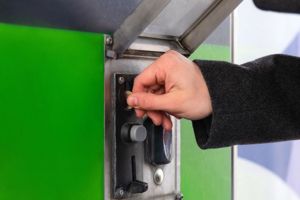 Hand turning a key in a green machine’s metal control panel