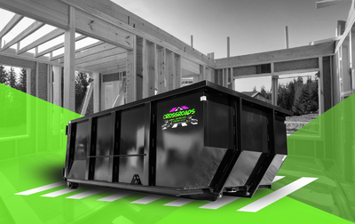 A dumpster is sitting in front of a building under construction.