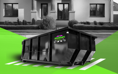 A black and white photo of a dumpster in front of a house.