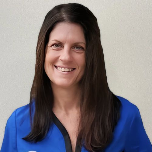 A woman in a blue shirt is smiling for the camera