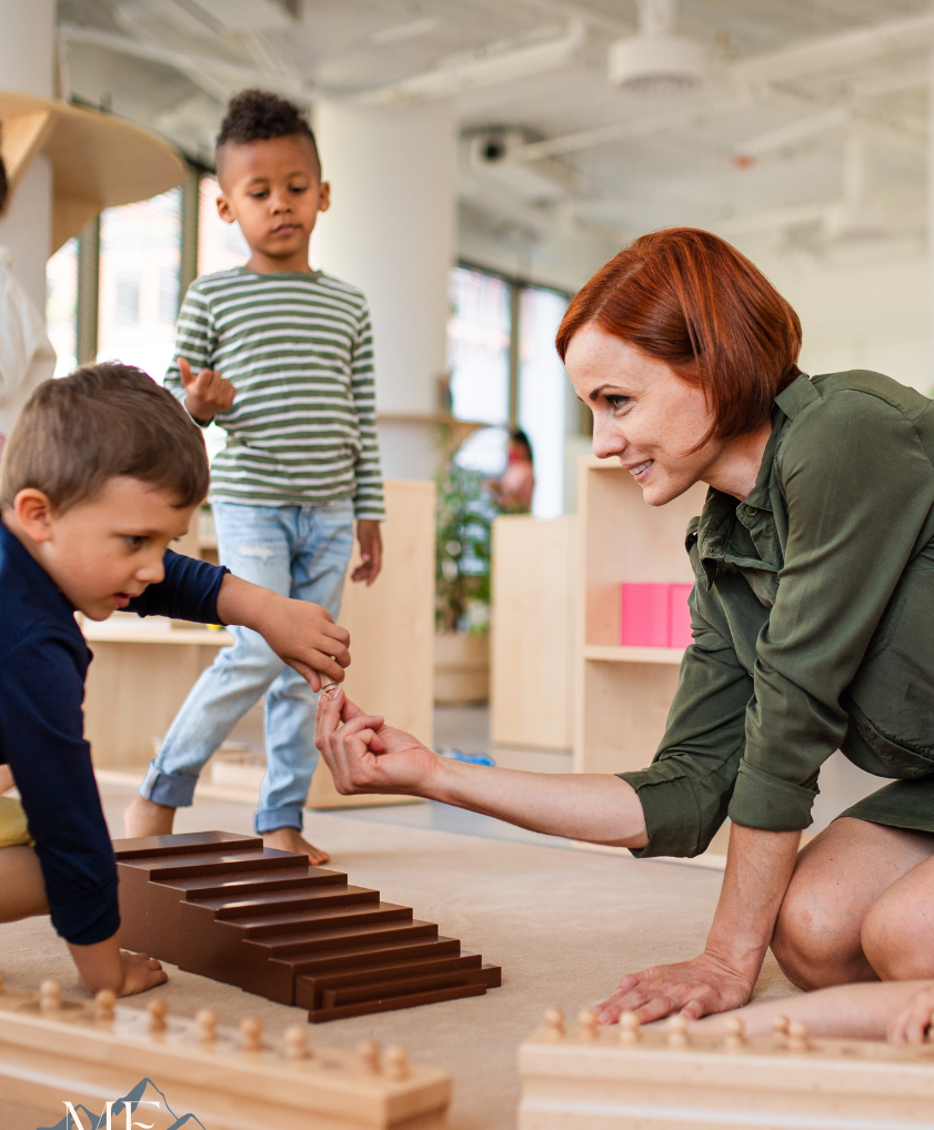 A woman is kneeling down next to two children playing with wooden toys.