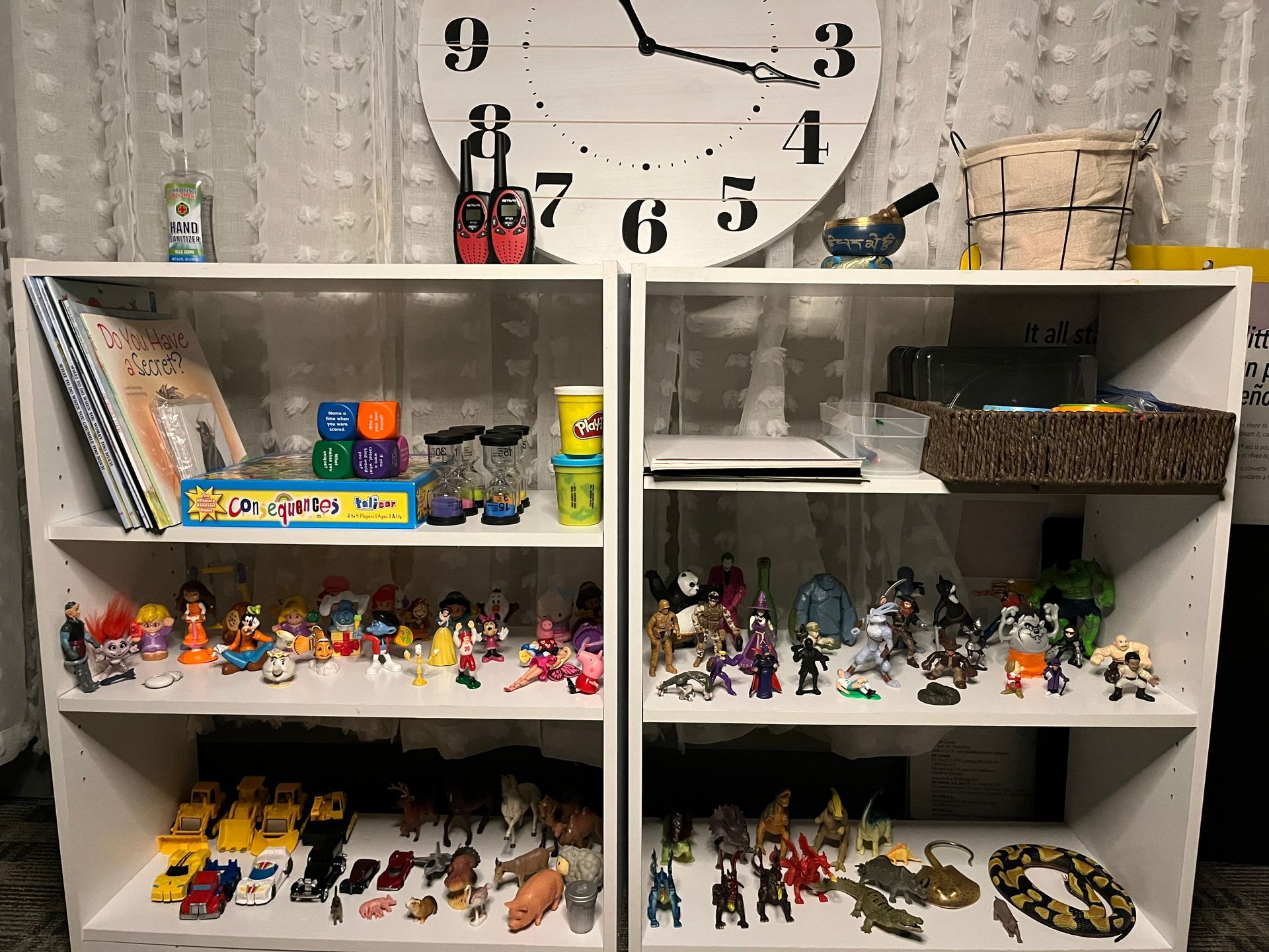 Two shelves filled with toys and a clock on the wall.
