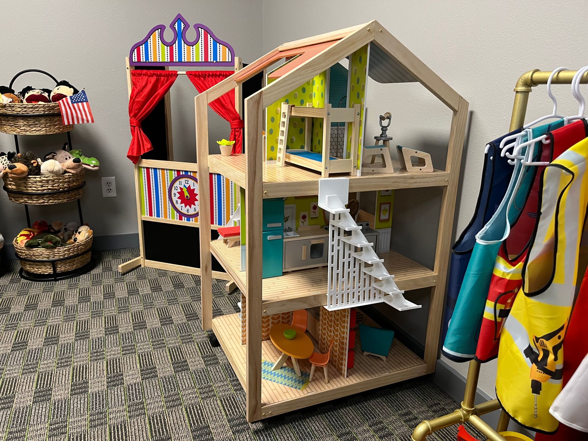 A doll house is sitting on top of a wooden shelf in a room.