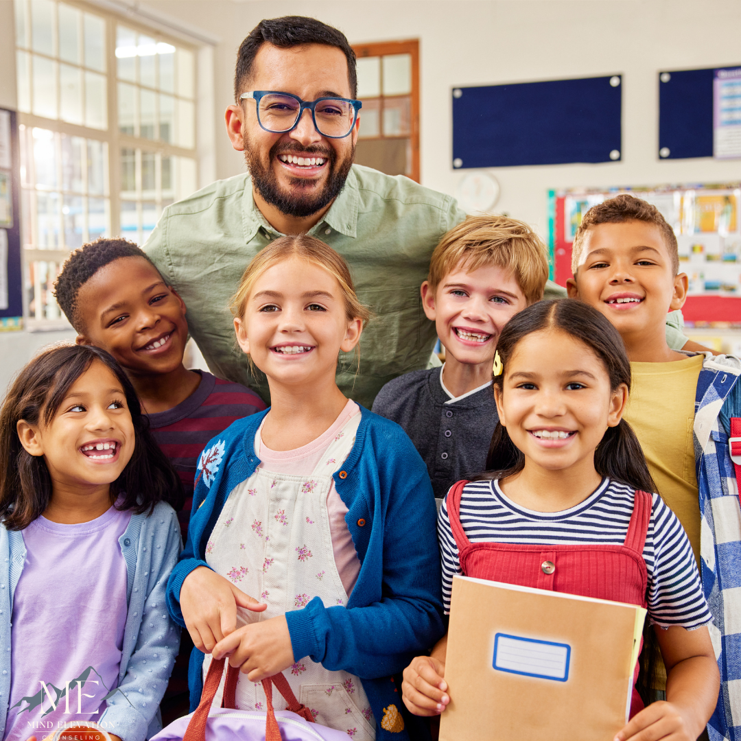 A group of children are posing for a picture with their teacher in a classroom.