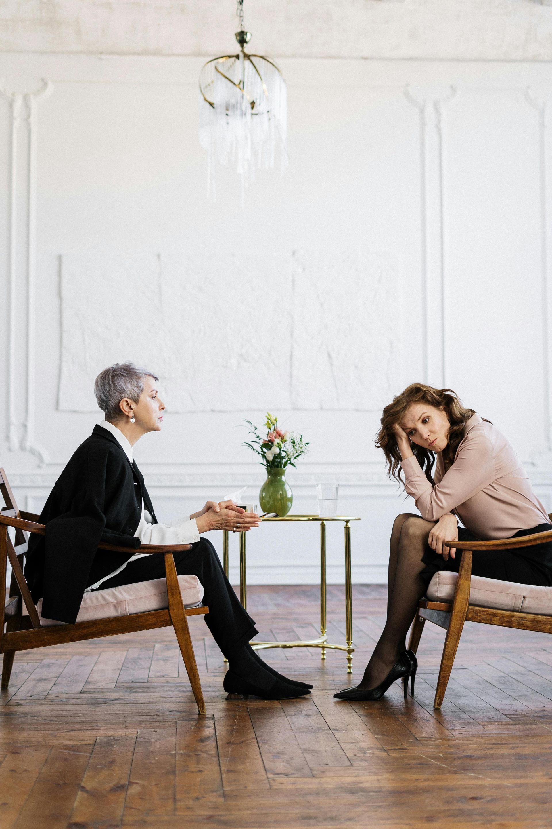 A woman sitting on a couch talking to another woman