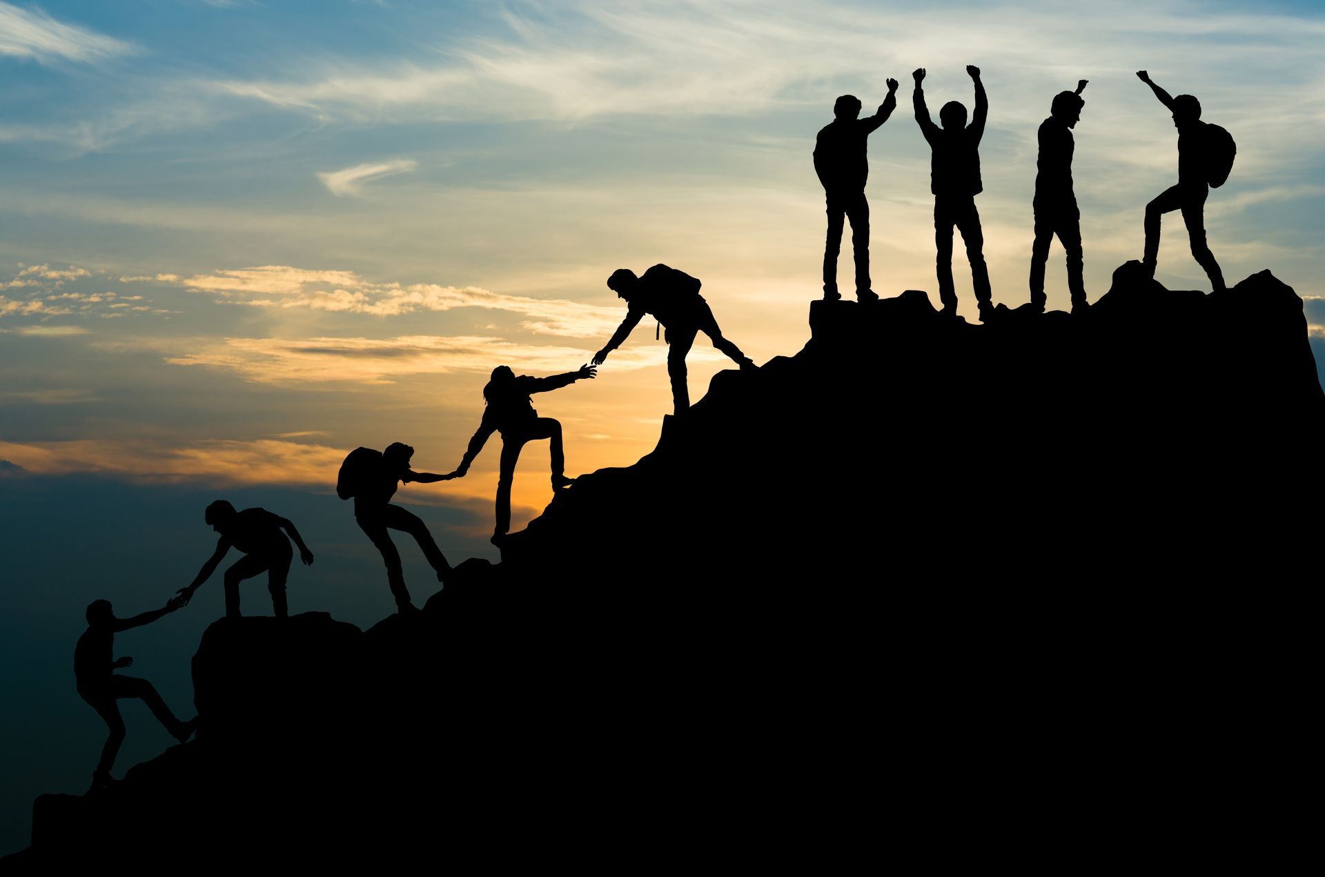 A group of people are standing on top of a mountain.