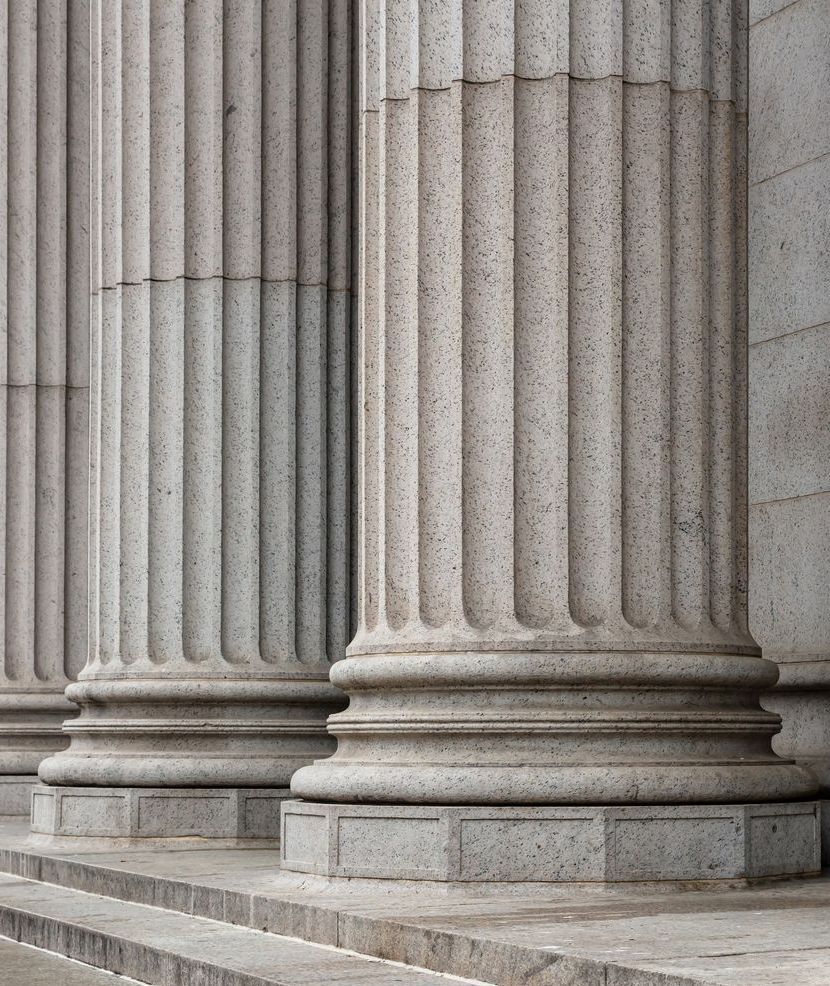 A row of columns on the side of a building with stairs leading up to them.