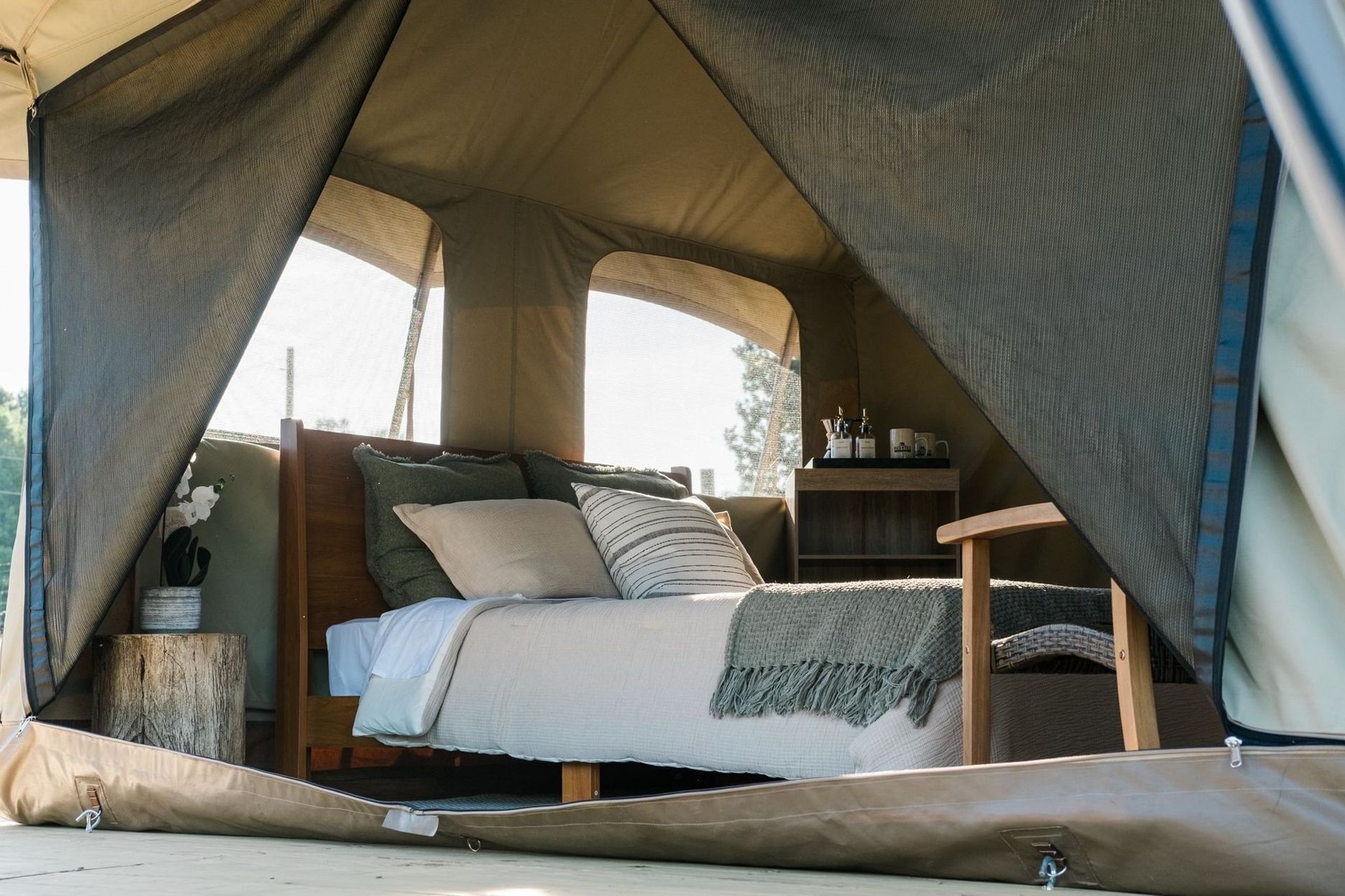 A tent with a bed and chair inside of it.