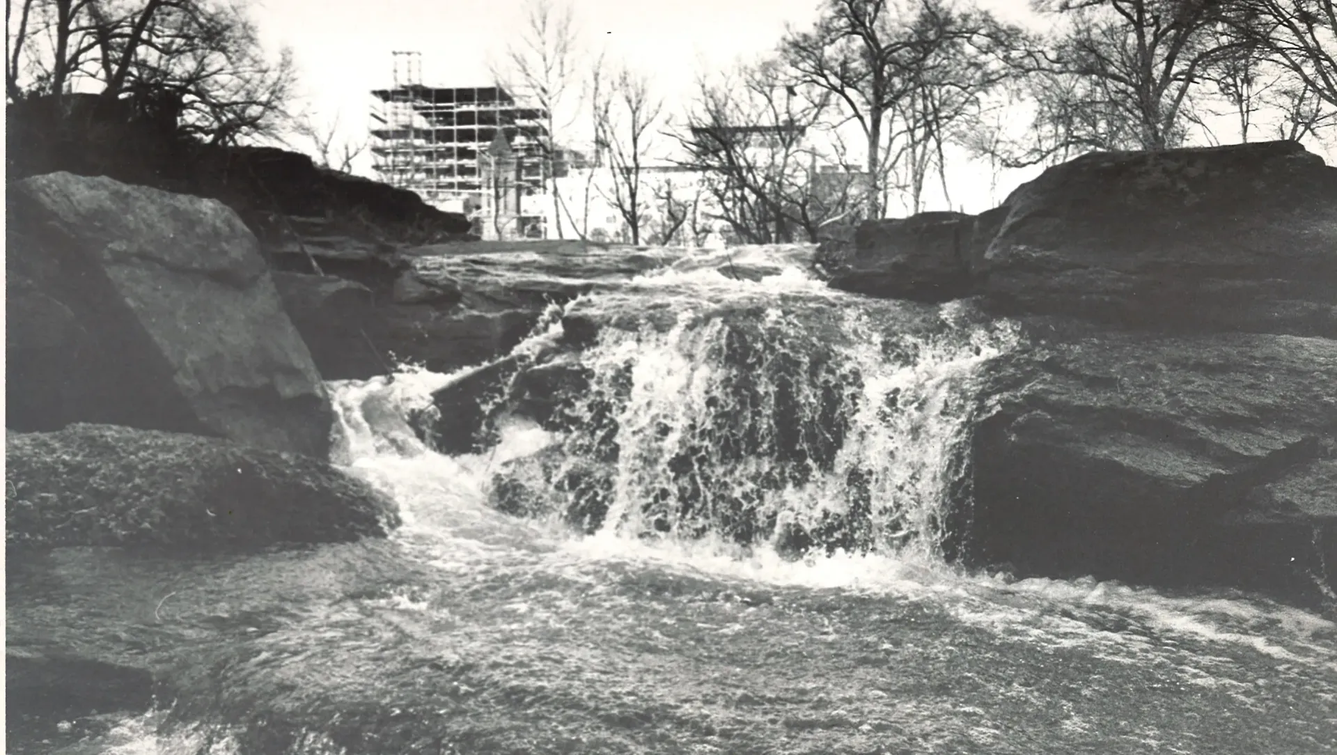 A black and white photo of a waterfall in a park