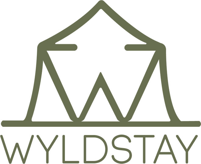 A logo for a company called wyldstay with a tent in the middle.