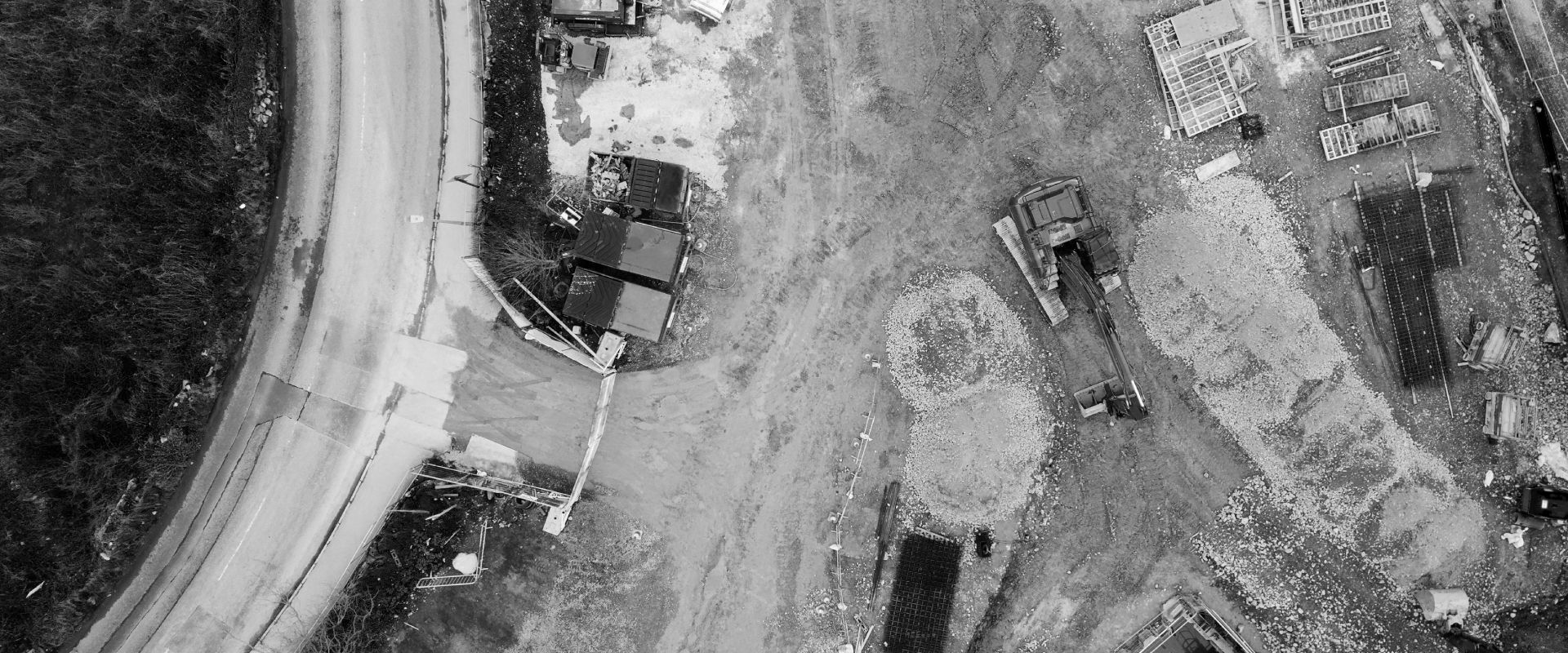 An aerial view of a construction site with a road and buildings.