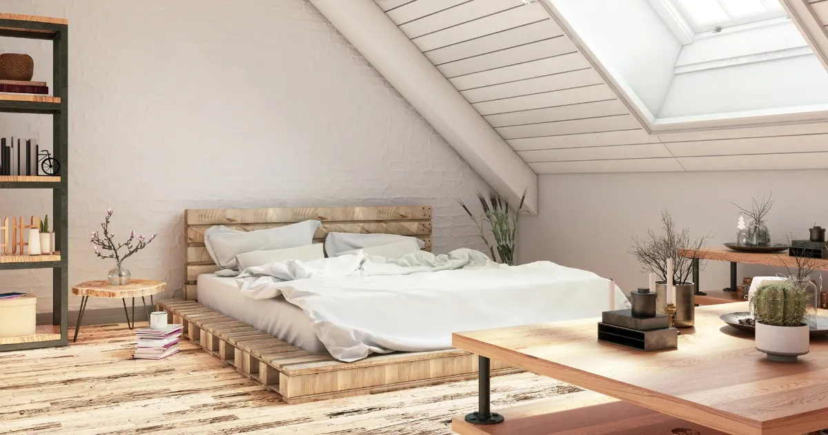 A bright attic bedroom with a low wooden platform bed and soft daylight, for cozy attic loft conversion ideas
