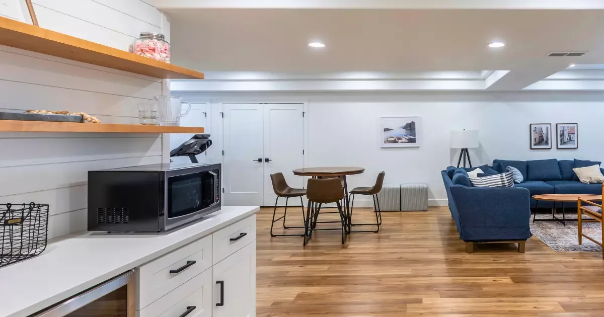 Modern open-concept living area with kitchenette and seating, showcasing professional basement finishing