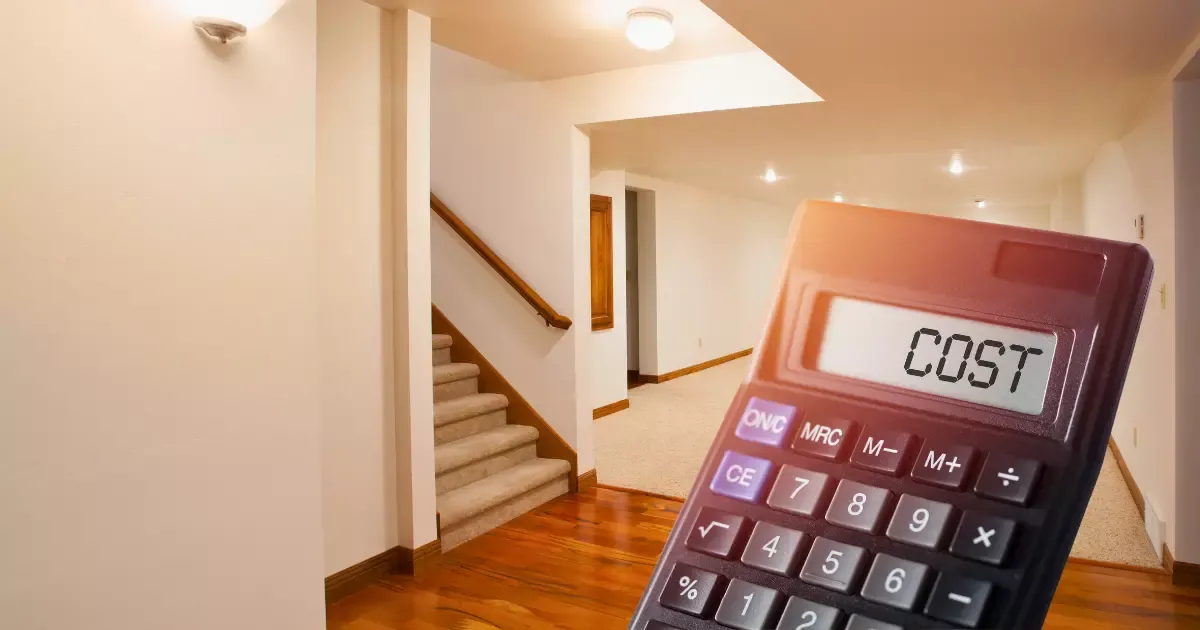 Calculator in front of a renovated lower-level living area, highlighting basement finishing costs