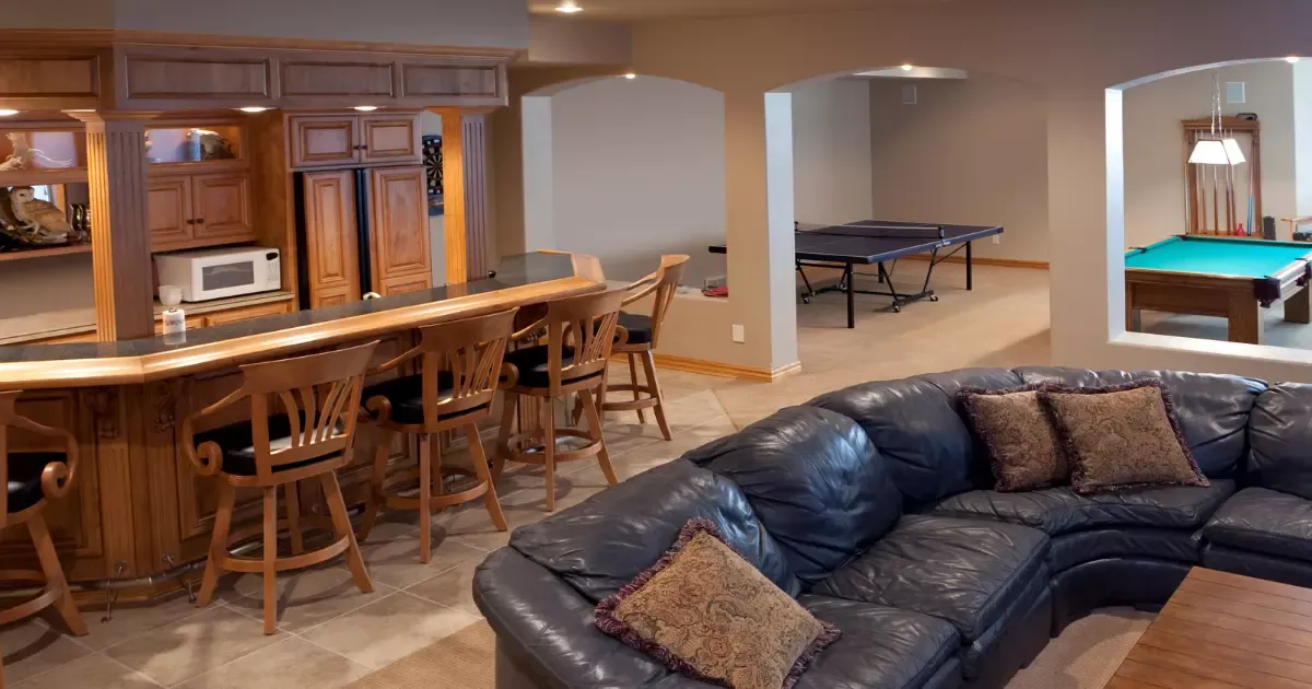 Spacious basement remodeling with custom bar, seating area, and game room featuring pool and ping pong tables
